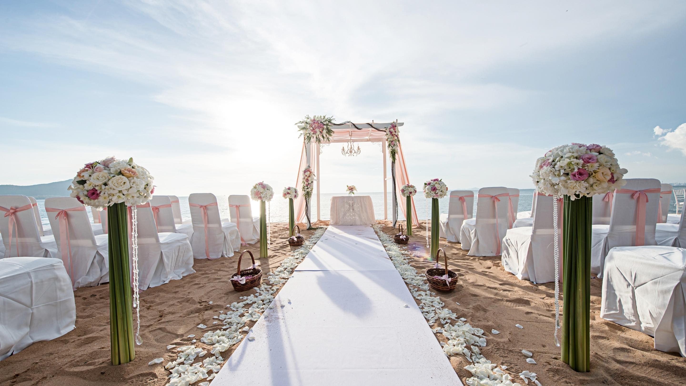 destination wedding ceremony with gazebo on beach with white carpet and white flower 