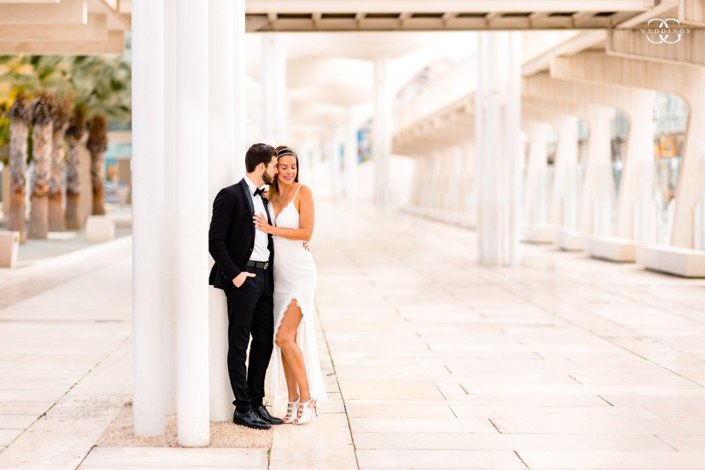 bride and groom cuddling in for a lovely romantic moment during their destination wedding photoshoot in Malaga pier