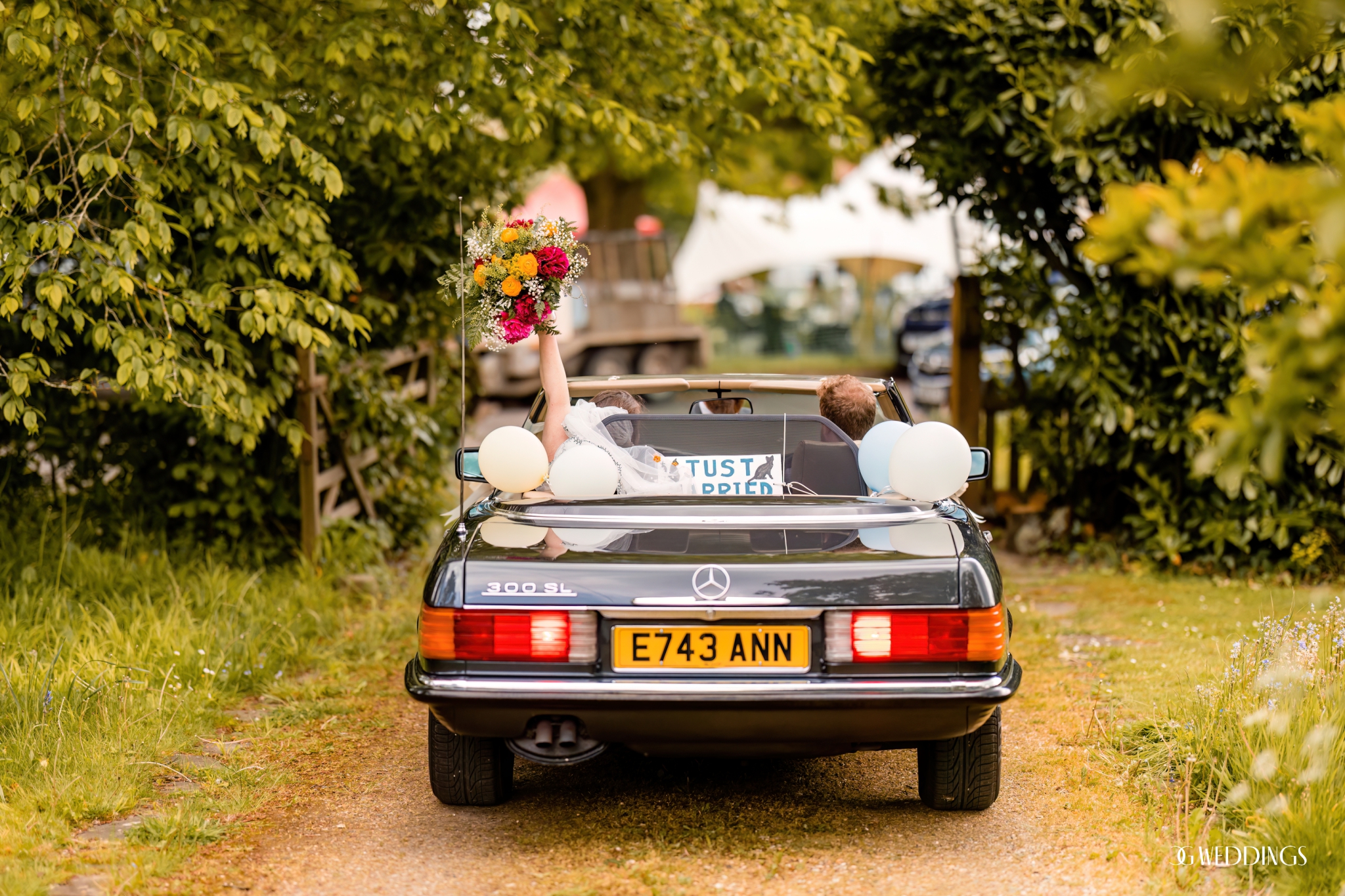 Marbella bride and groom drives away from wedding with just married sign and old mercedes
