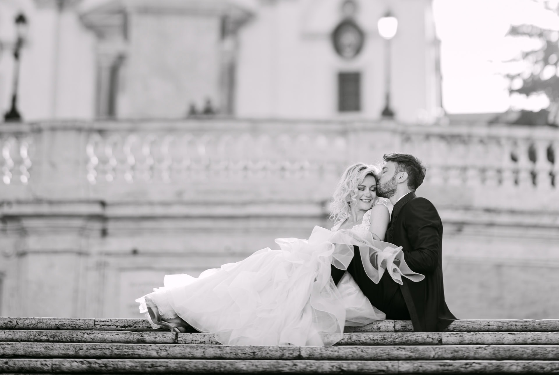 Bride and groom kissing on stone steps