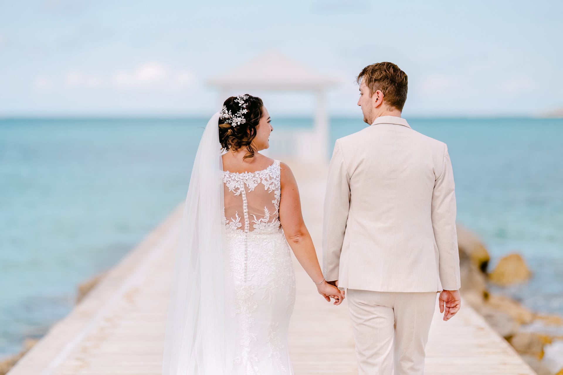 Bride and groom walking on seaside pier
