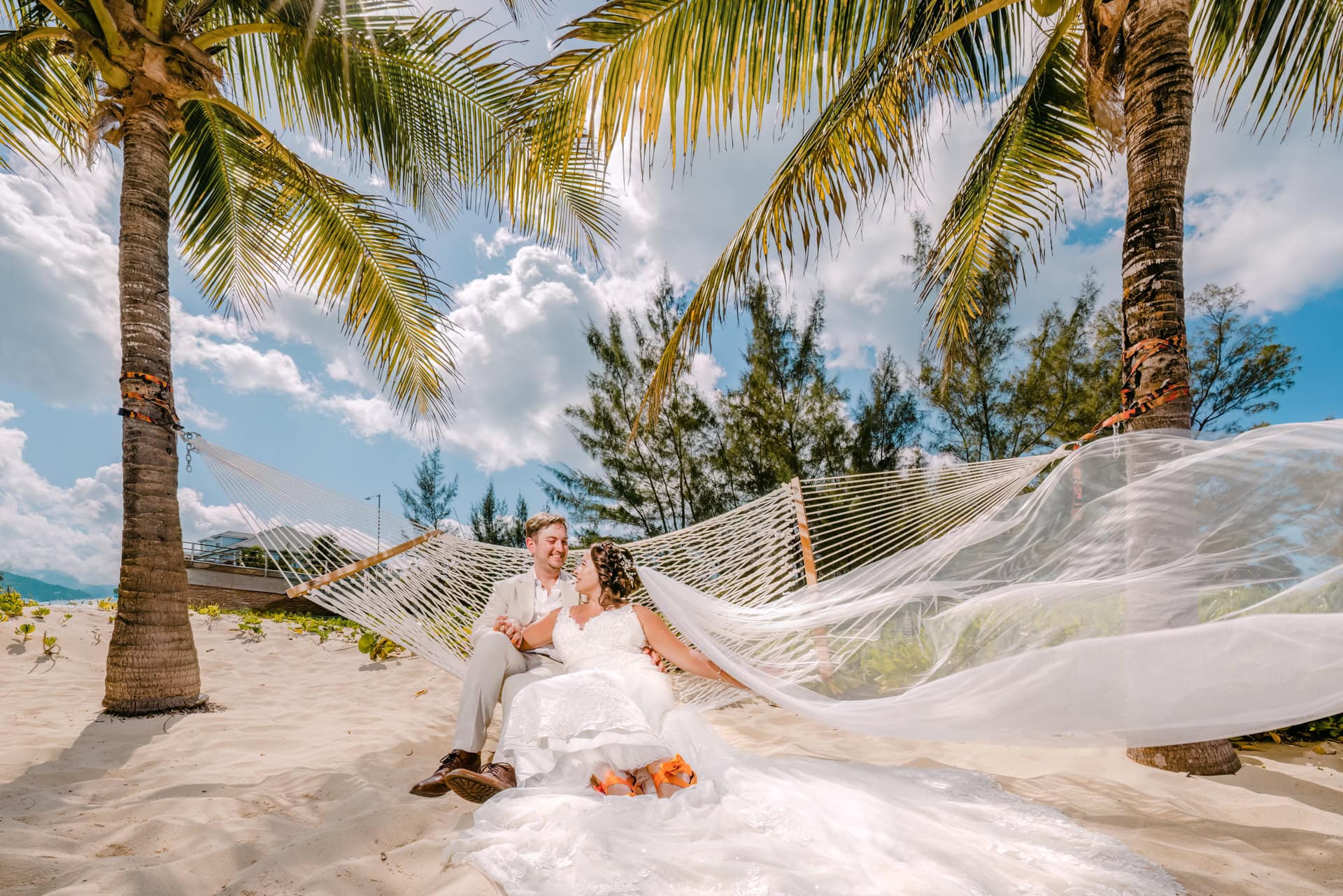 Bride and groom on tropical beach hammock