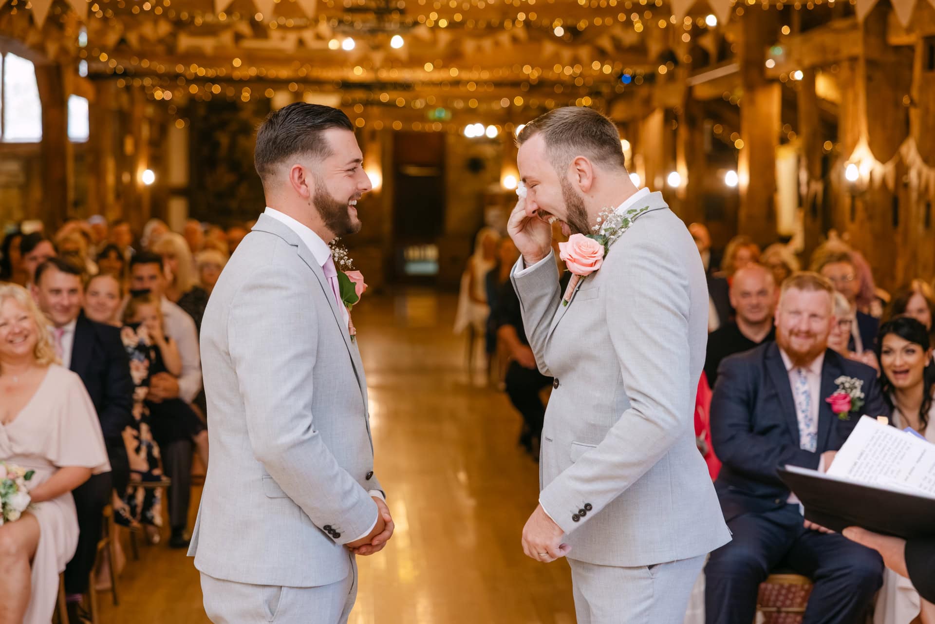 Two grooms sharing emotional moment during wedding ceremony