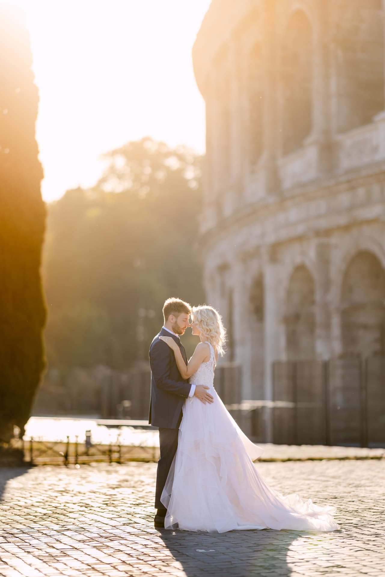 Bride and groom embracing at sunset outdoors