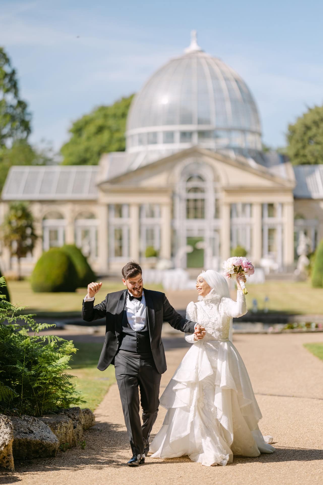 Bride and groom celebrating outside domed historic building