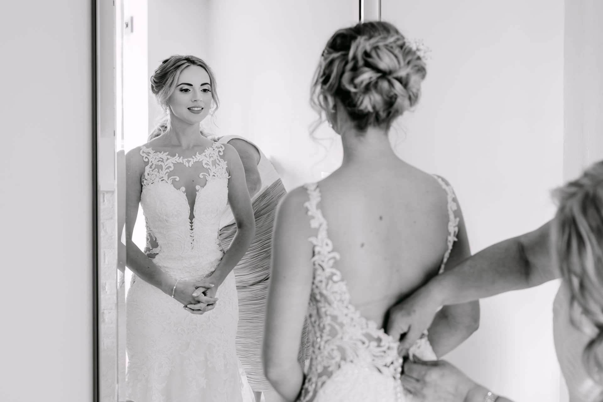 Bride admiring wedding dress in mirror