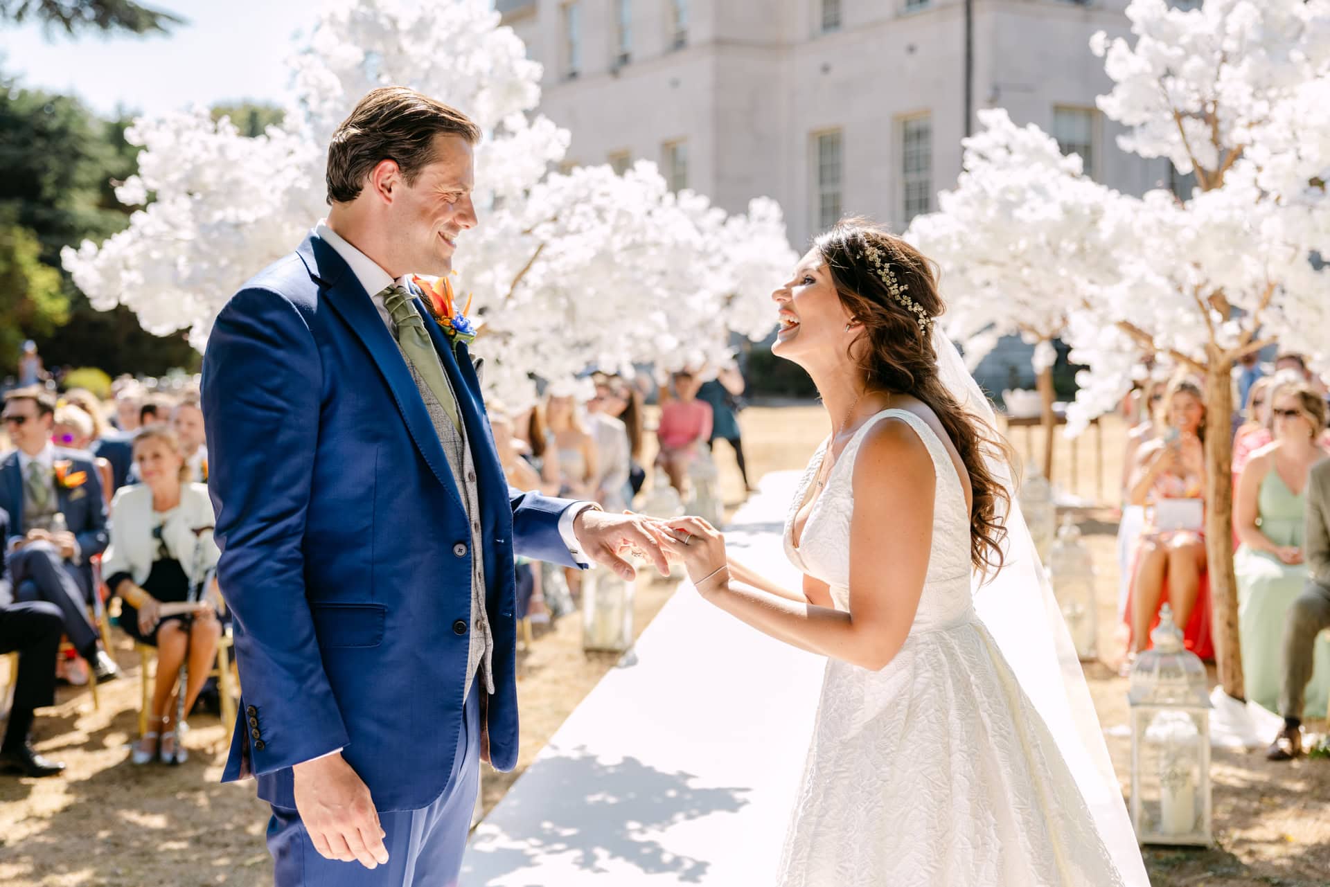 Wedding ceremony in Spain with bride and groom exchanging vows under blooming trees.