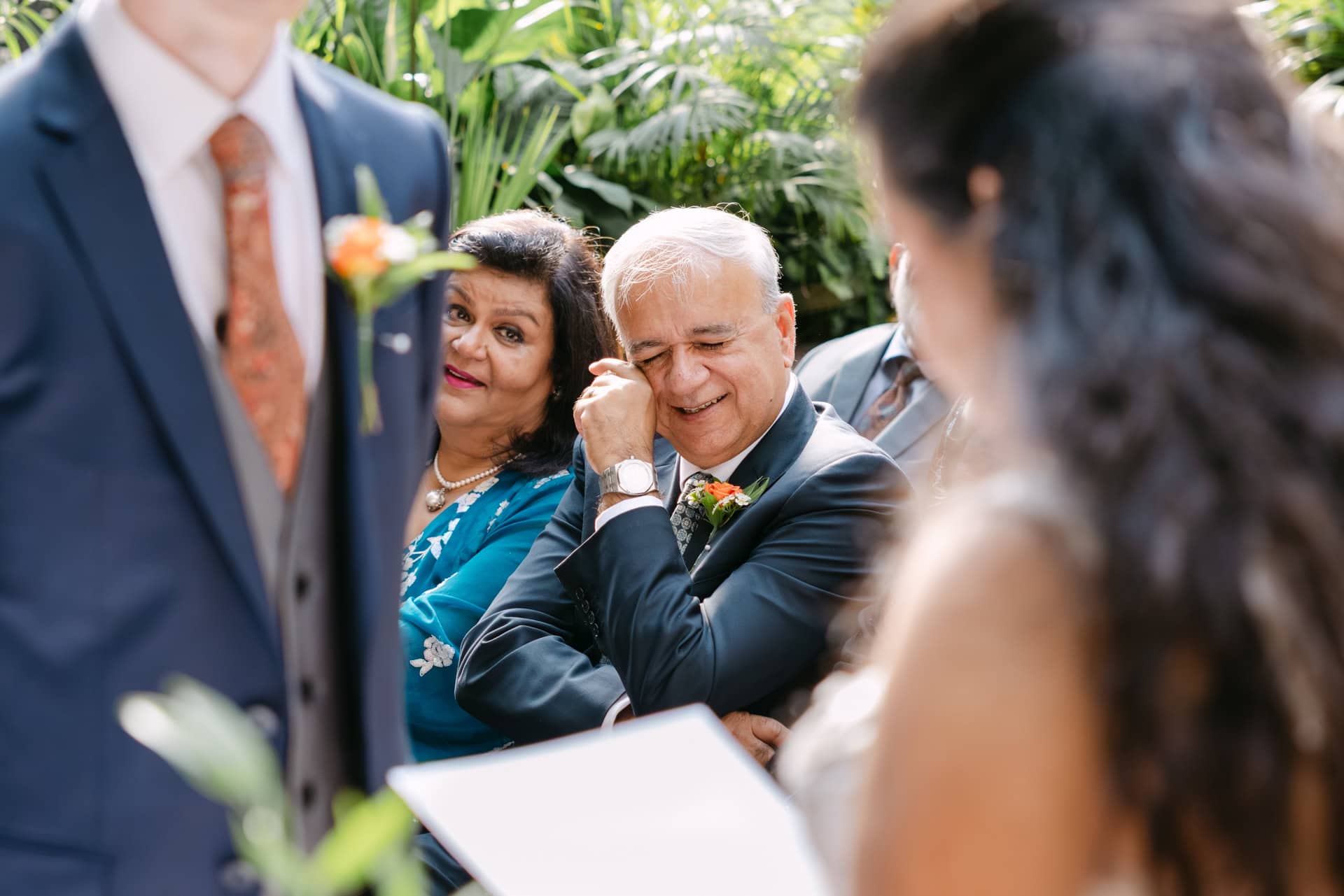 Emotional father of bride fob wiping tear at outdoor wedding ceremony while watching daughter getting married in Malaga