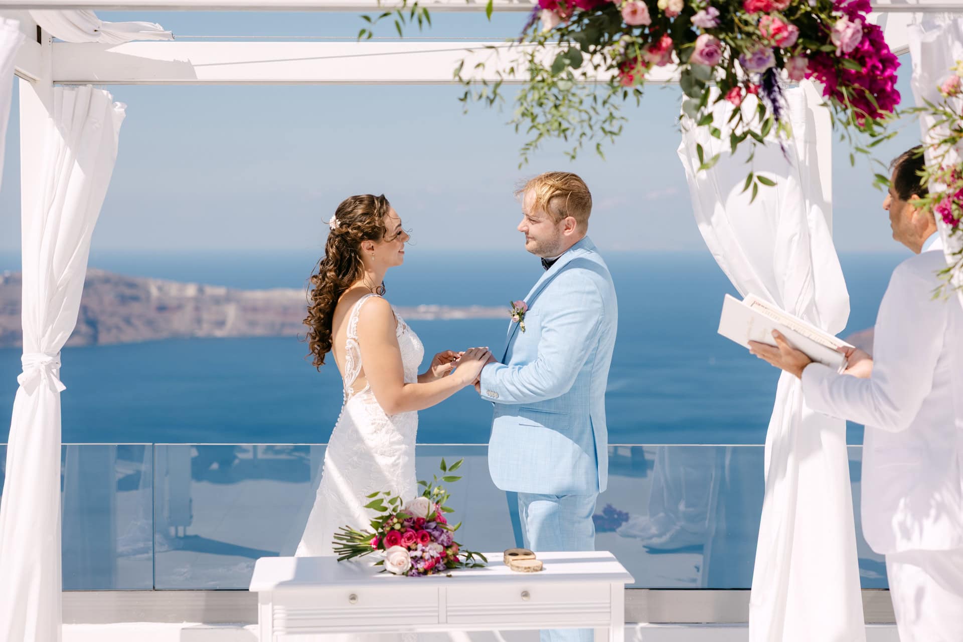 Bride and groom exchanging rings by the sea
