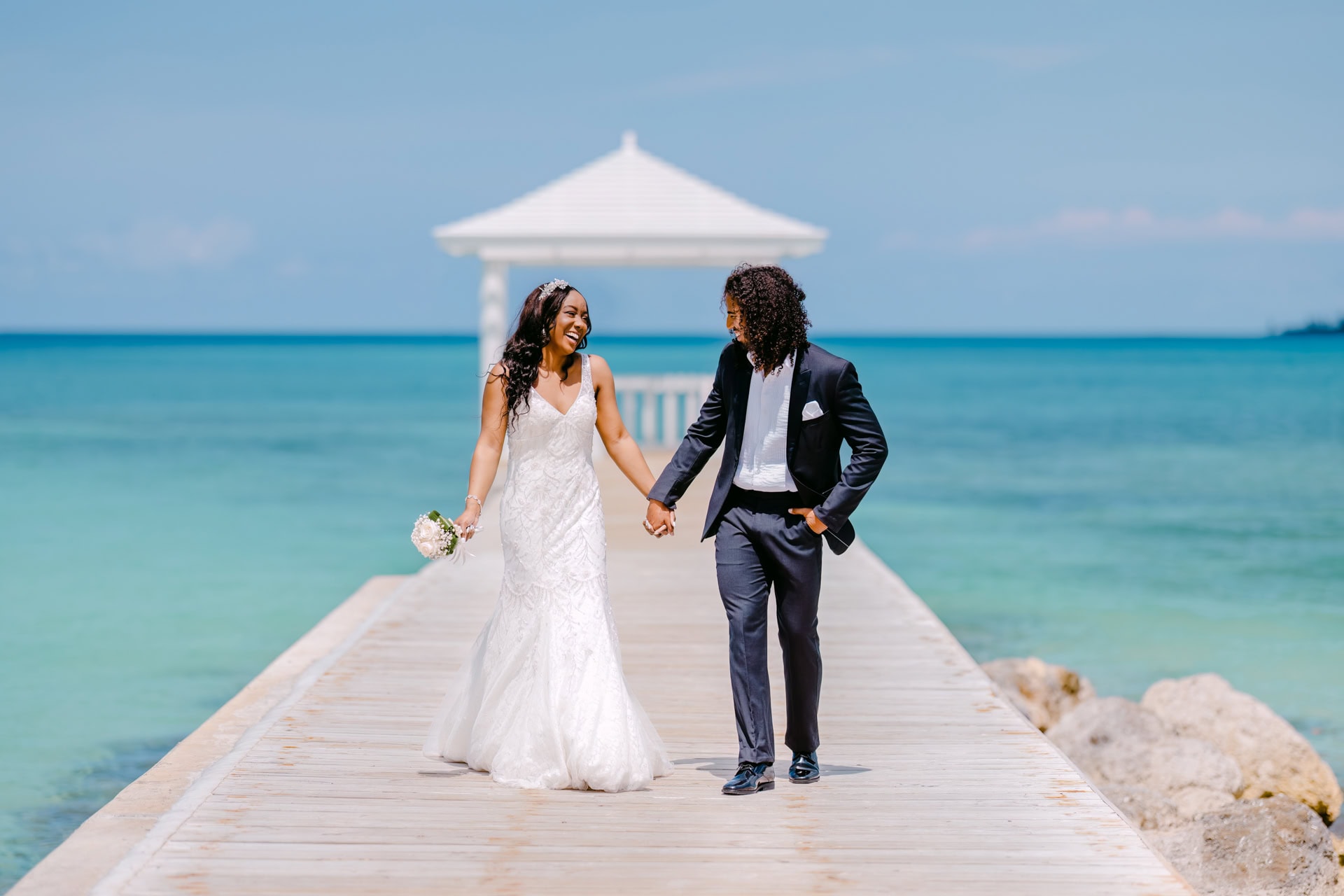 Bride and groom walking on seaside pier near Puerto Banus