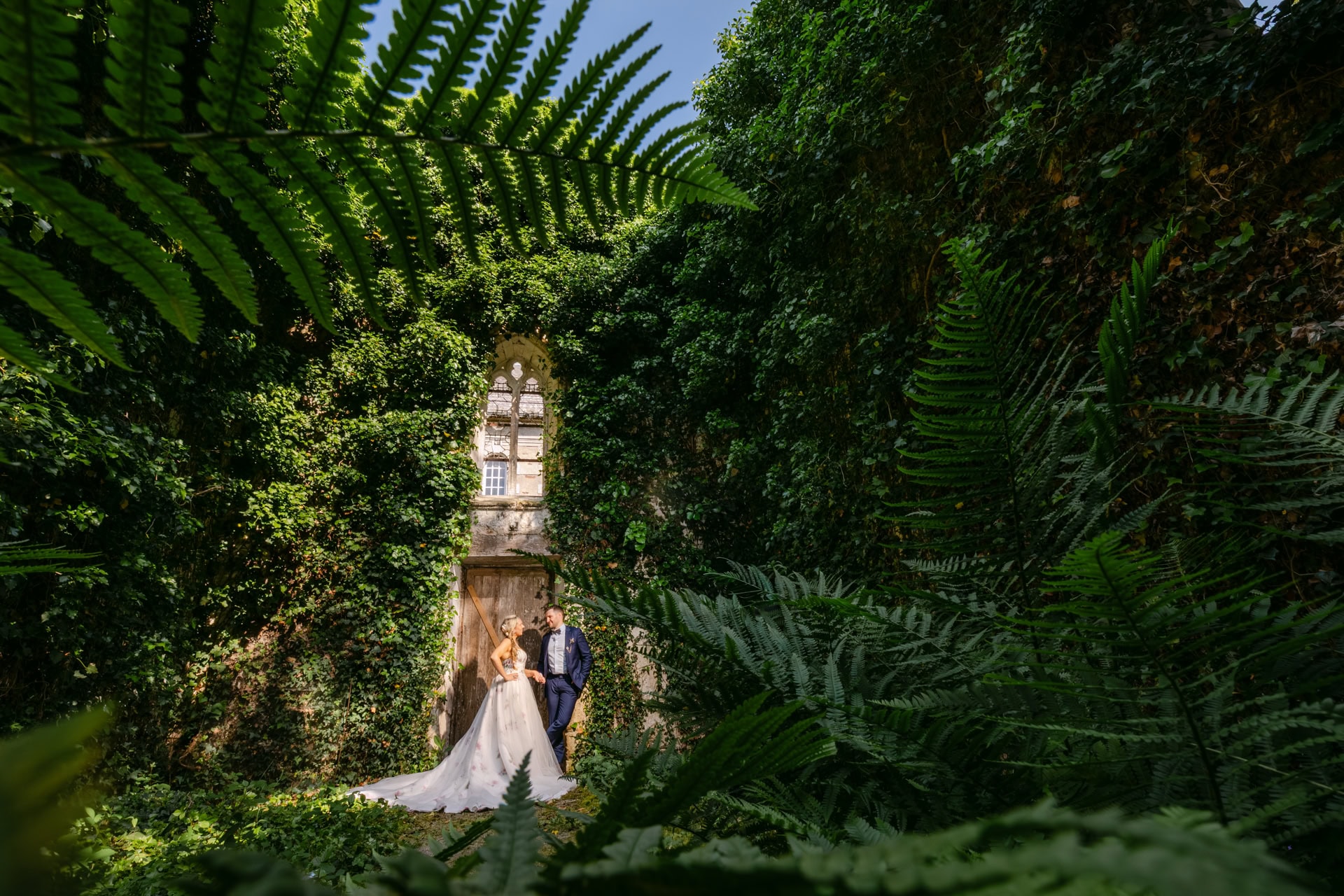 Bride and groom in lush ivy-covered ruins