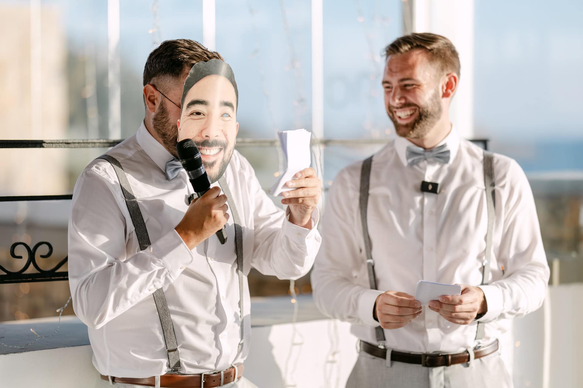 Groomsmen giving wedding speech with humorous face mask in Lindos, Greece on a destination wedding