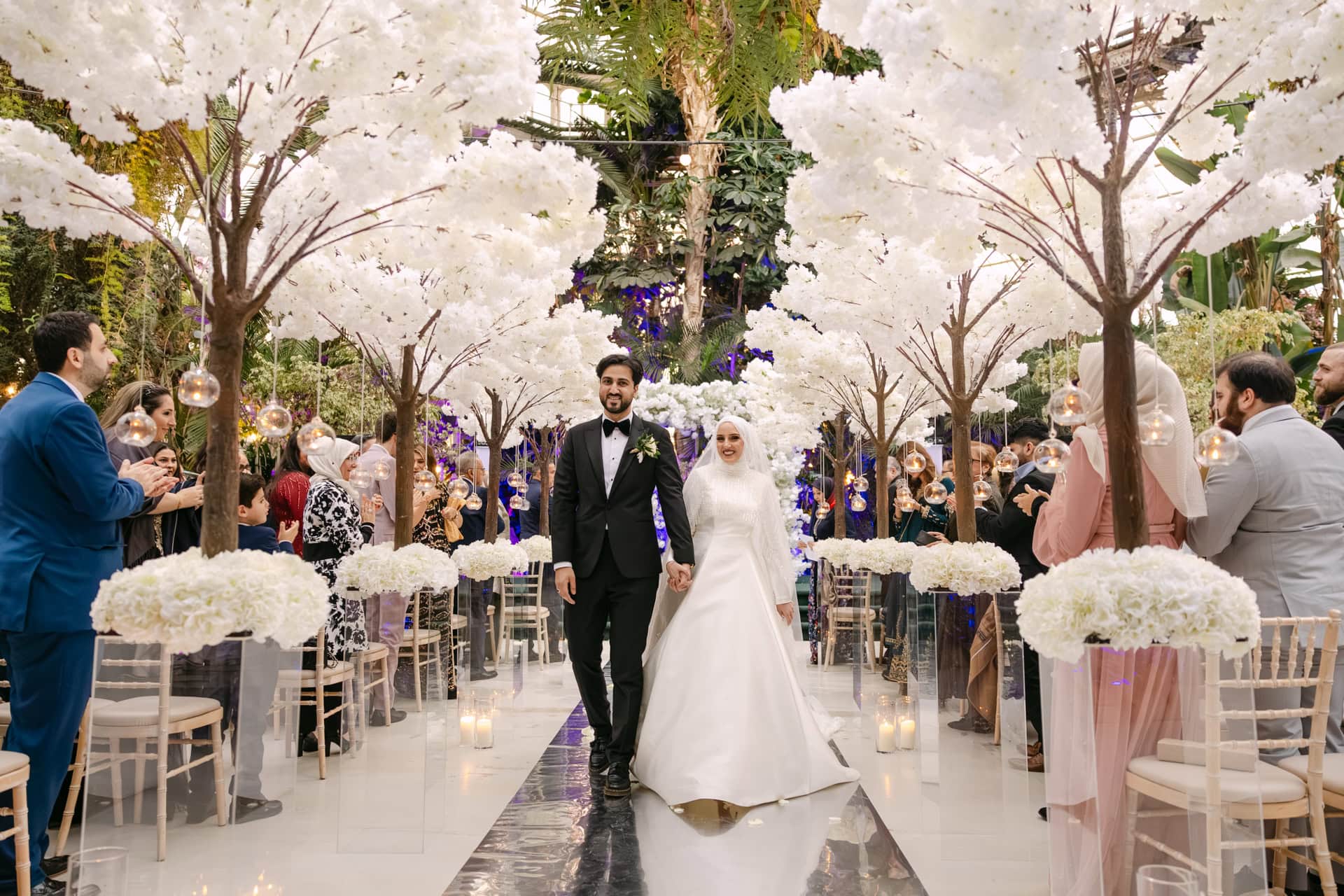 Bride and groom walking down floral wedding aisle