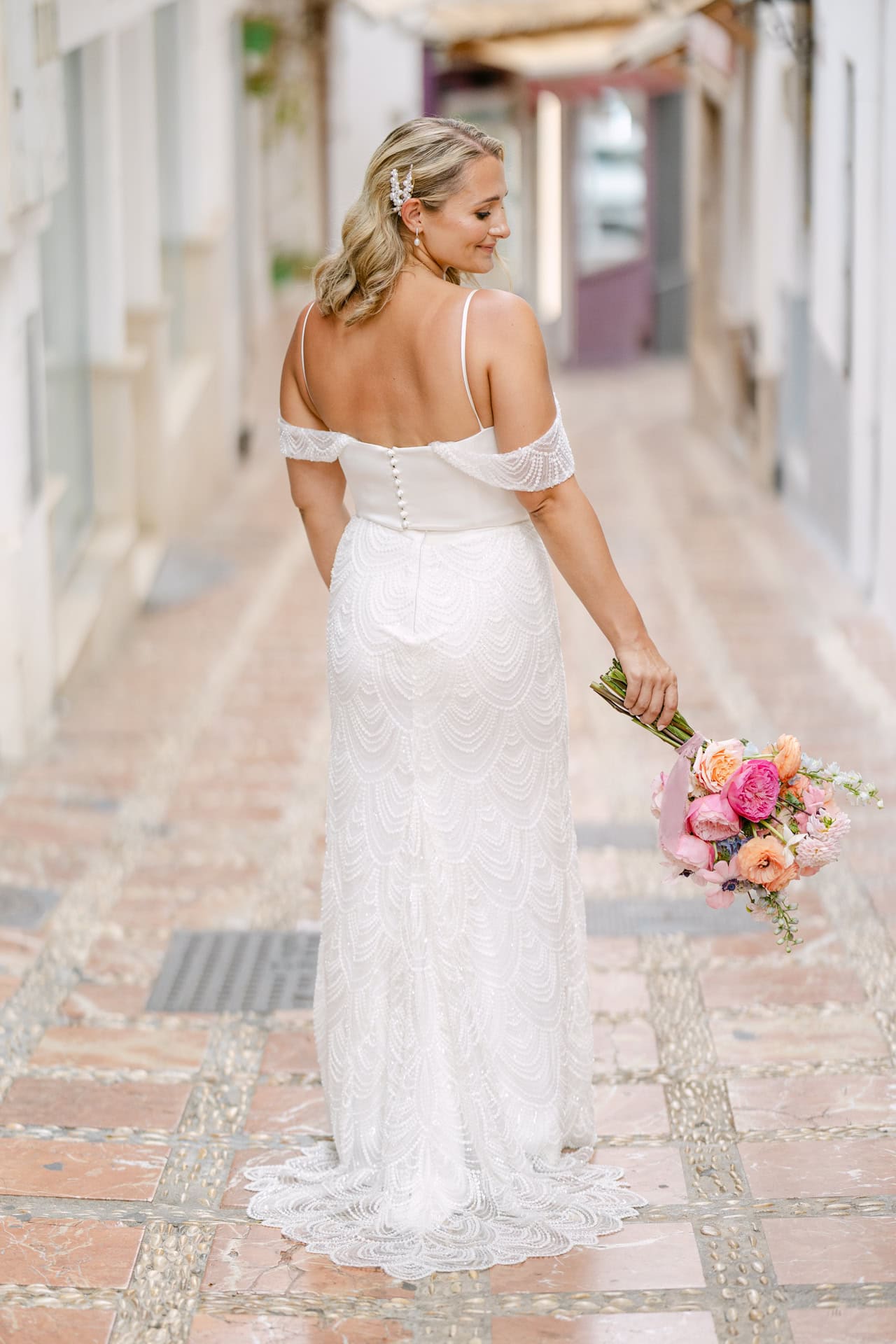 Bride holding bouquet in lace wedding dress in Marbella Old Town, near the Farm wedding venue