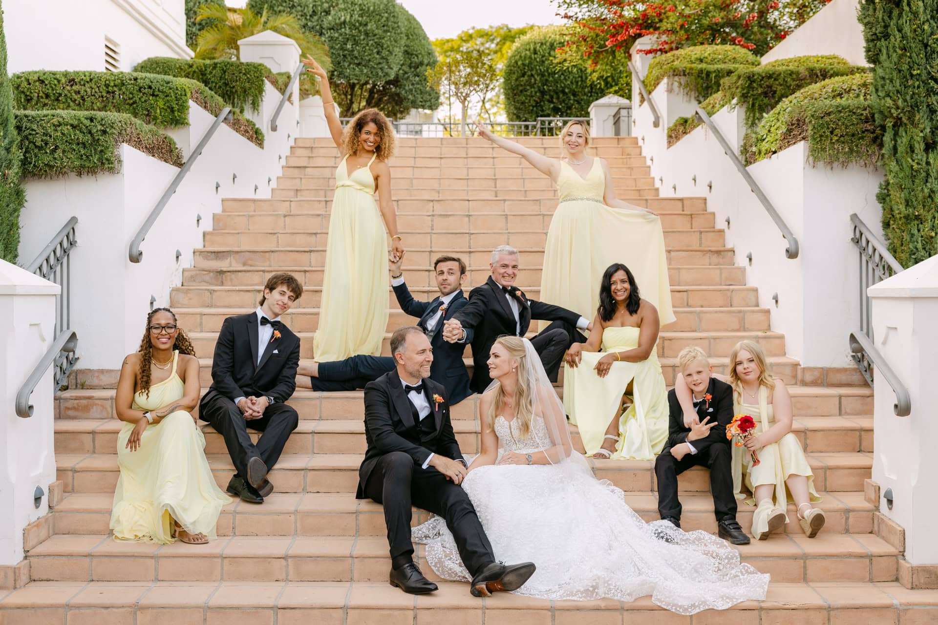 Wedding party posing on outdoor staircase in Spain, Marbella at the Westin La Quinta wedding venue.