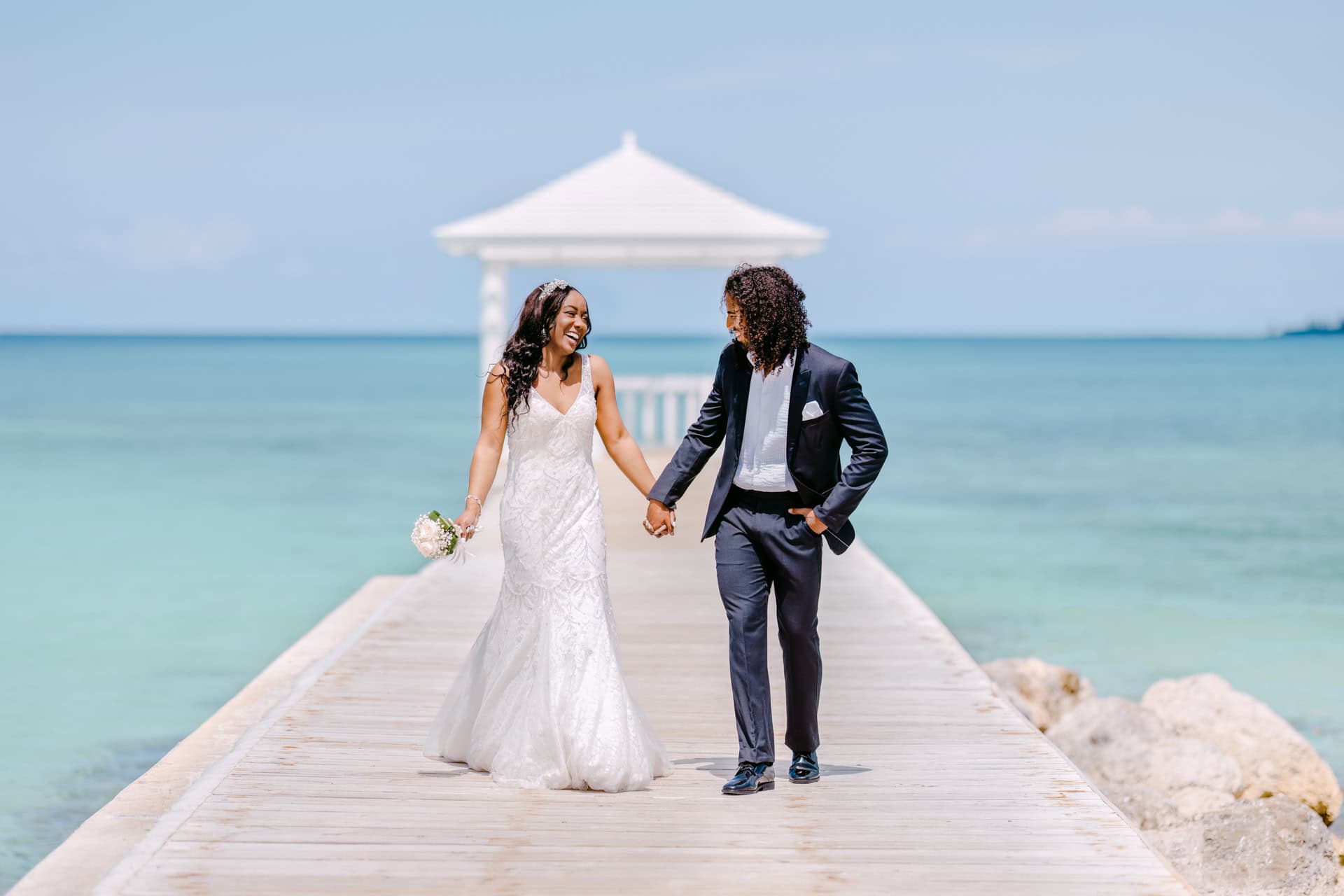 Bride and groom walking on seaside pier near Puerto Banus