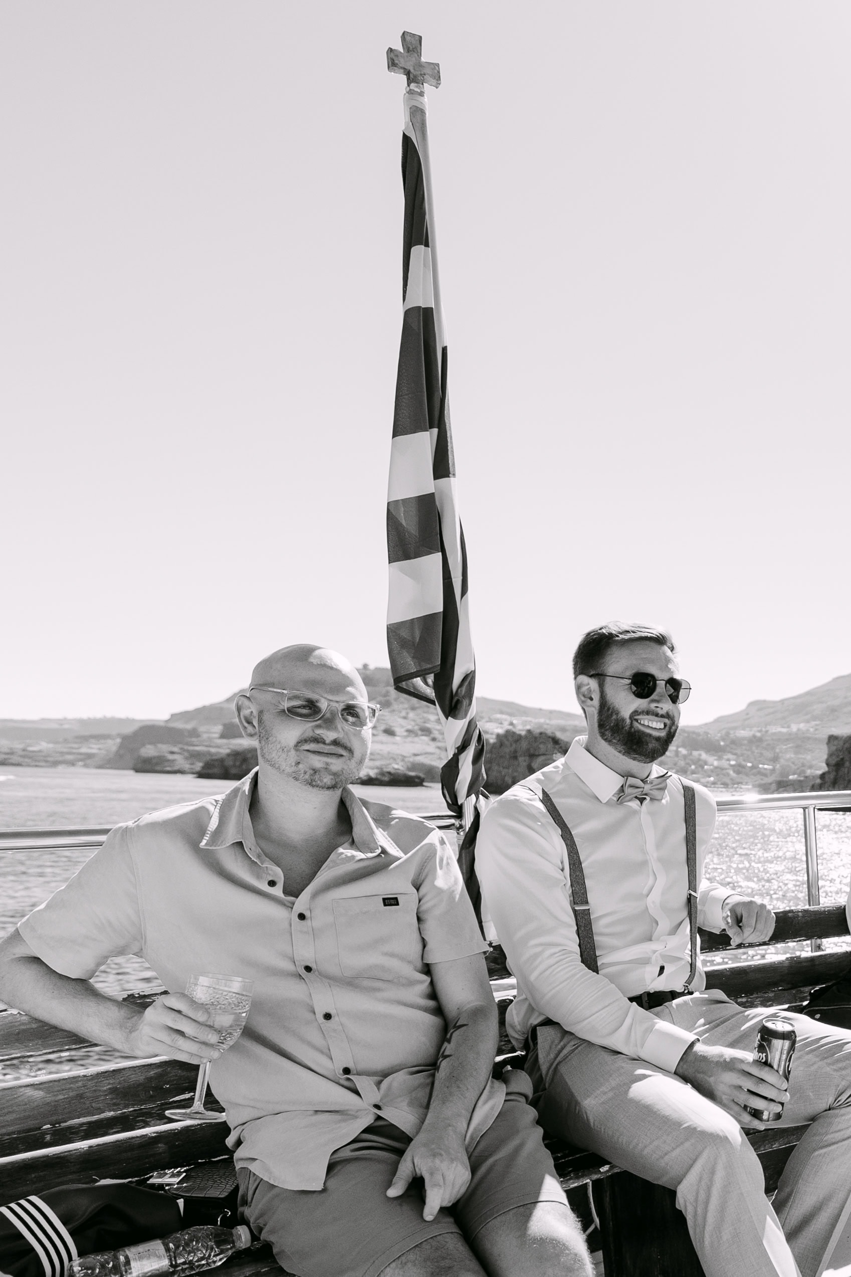 Two men relaxing on boat with coastal backdrop