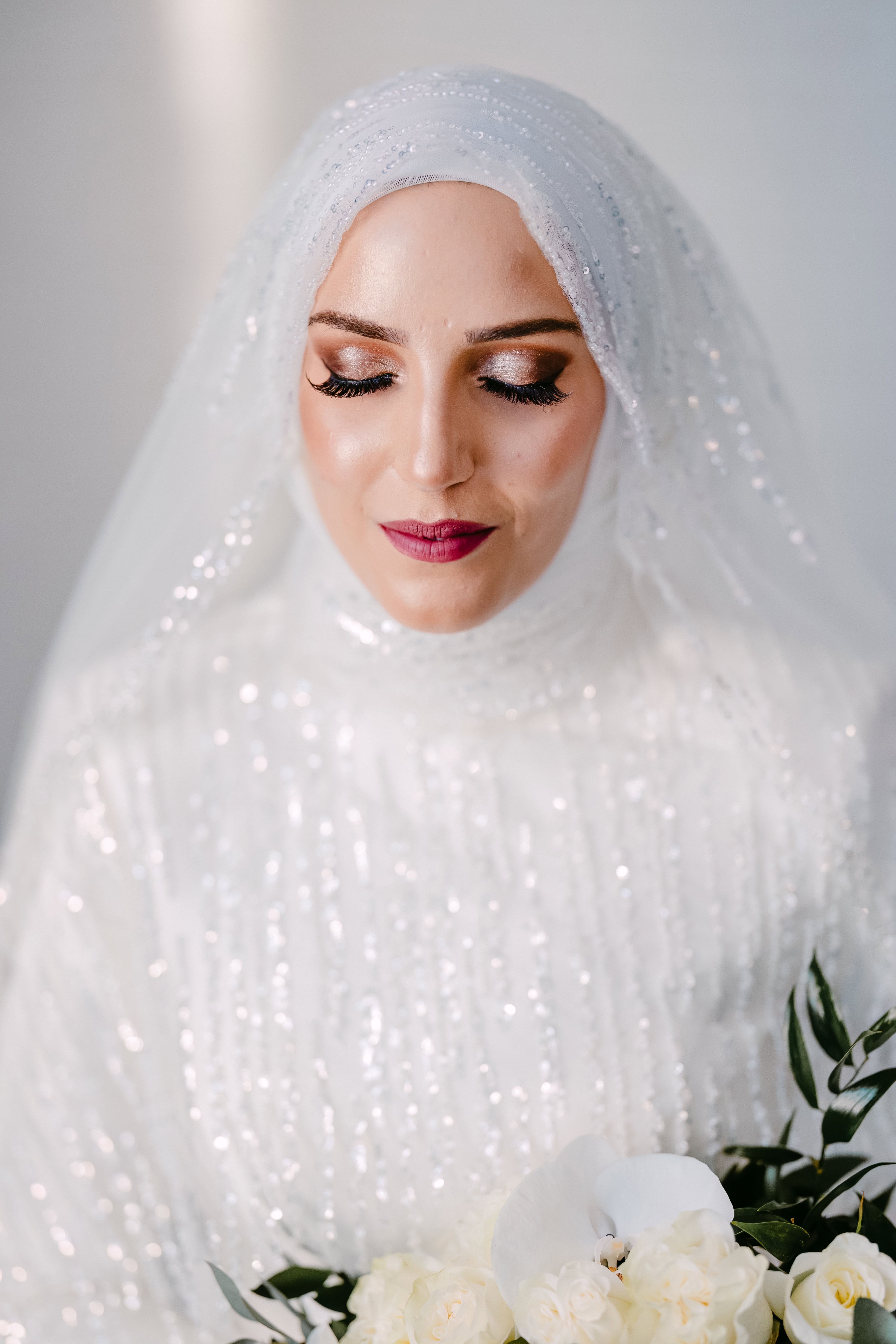 Bride in white sequinned veil holding bouquet