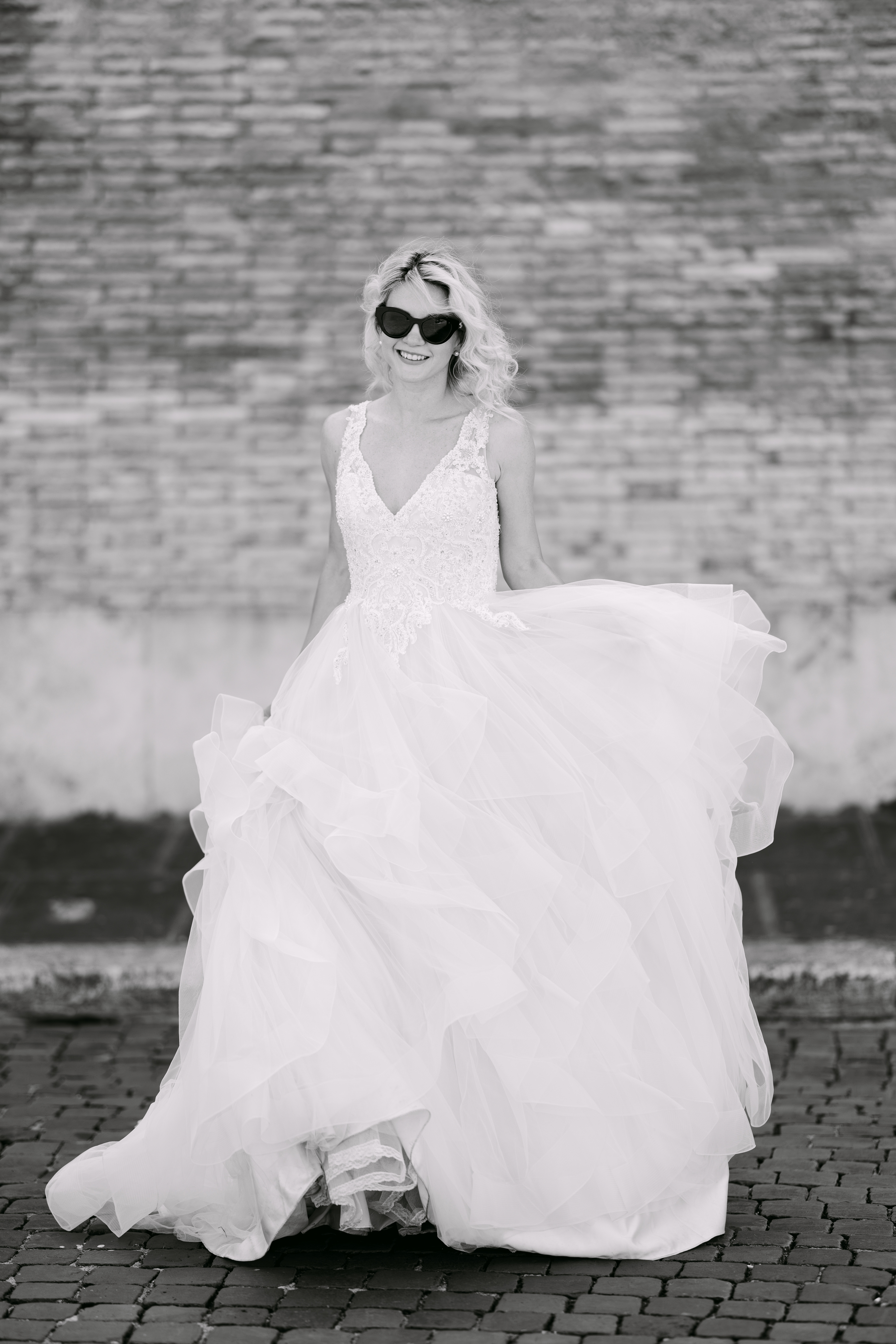 Bride in sunglasses wearing flowing wedding dress