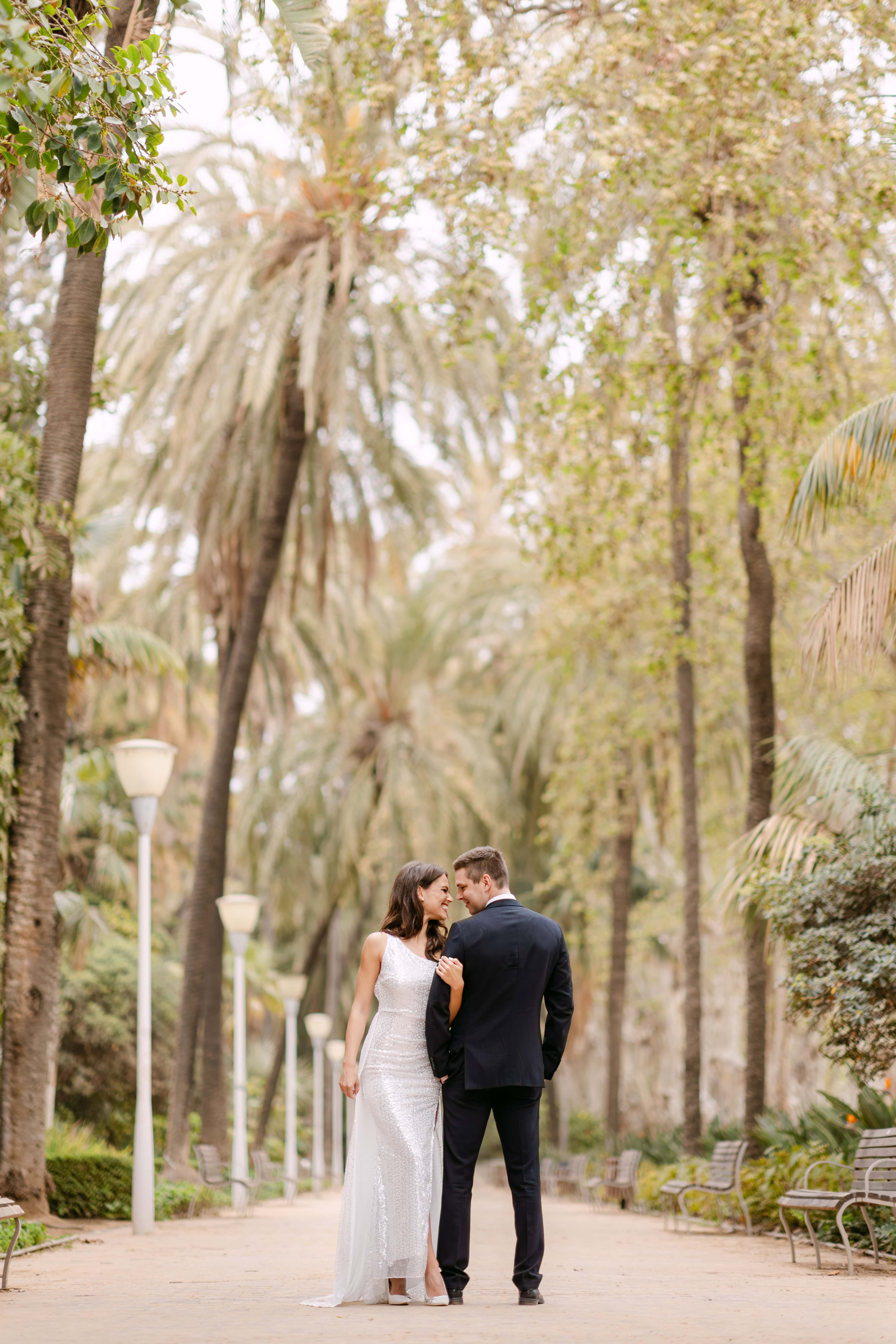 Bride and groom wedding photo in palm-lined Parque de Malaga in Spain, Malaga