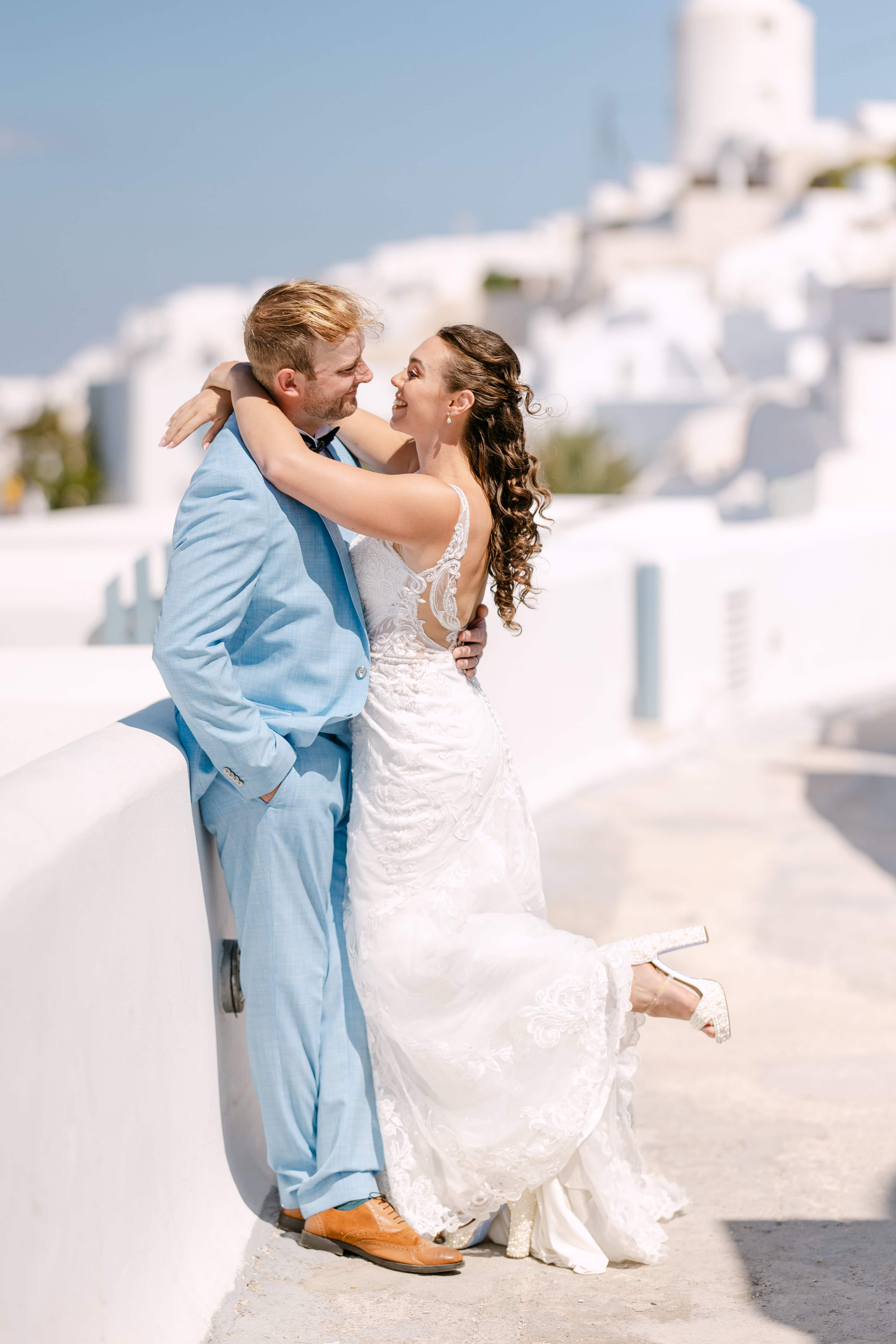 Bride and groom embracing in sunny white village in Mijas Costa, Spain