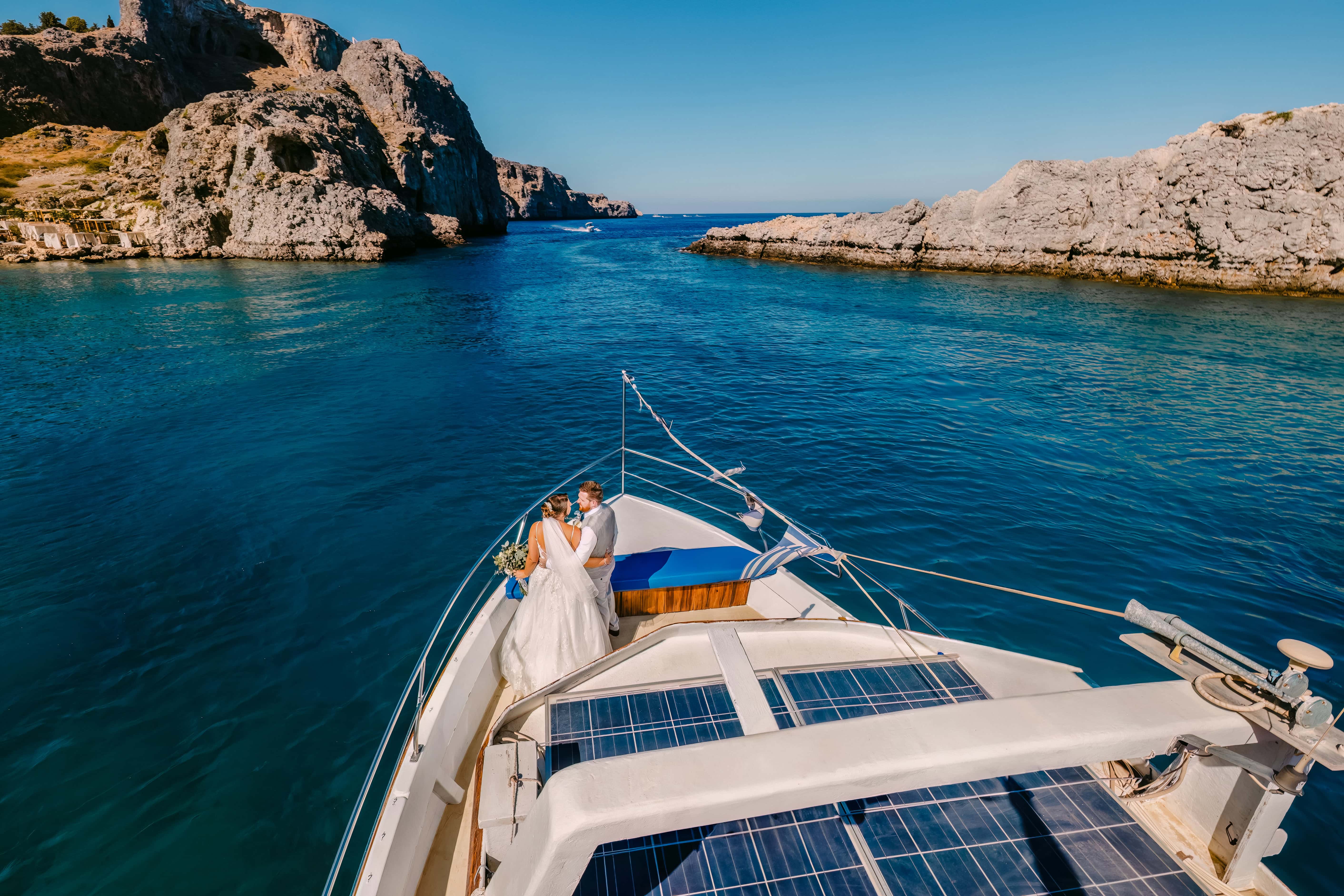 Bride and groom on yacht in turquoise cove near Puerto Banus Marbella