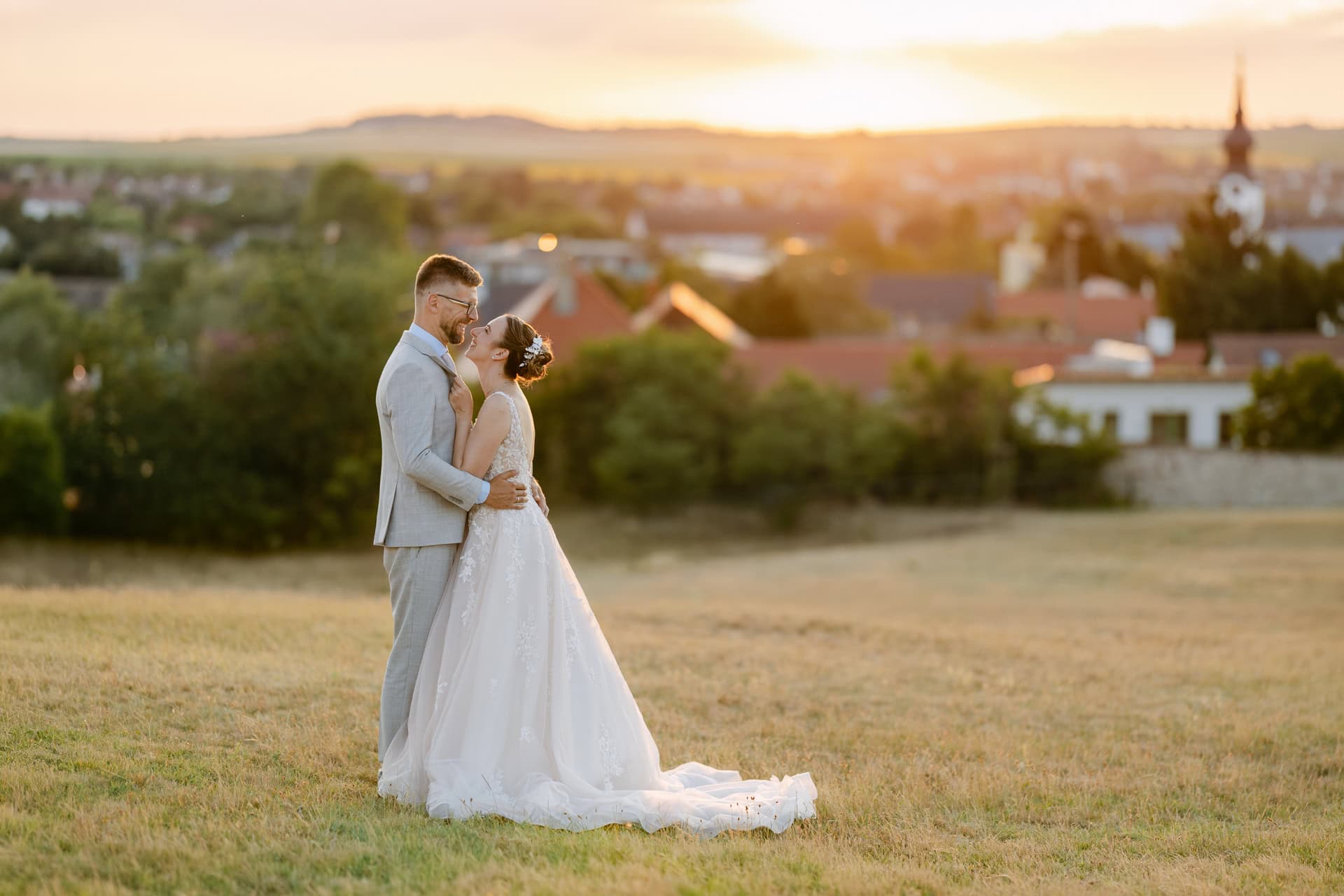 Bride and groom embracing at sunset in field for their destination wedding in Europe
