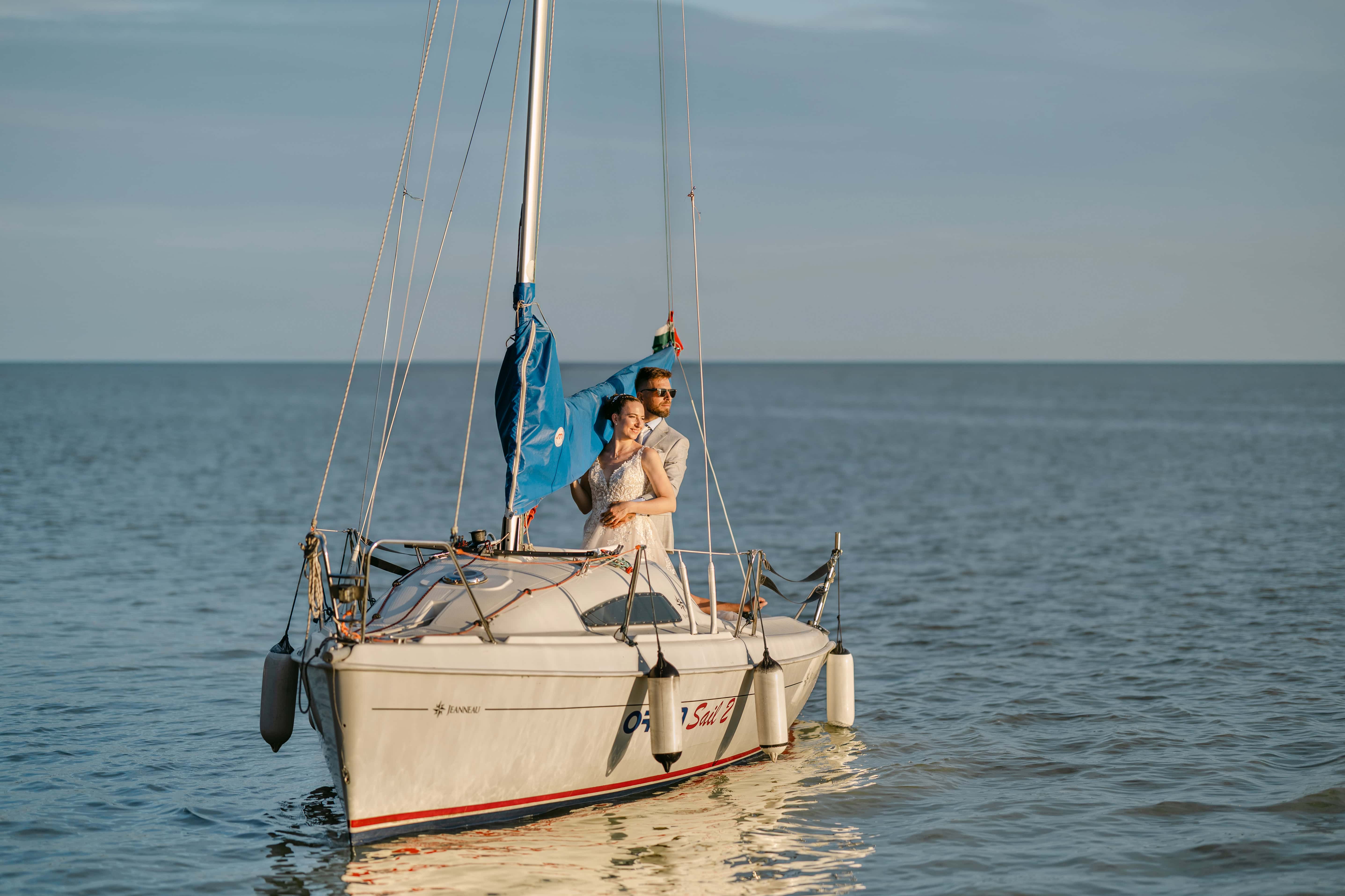 Bride and groom on sailboat at sunset